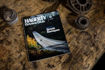 Hagerty Drivers Club magazine on a workbench with car parts.