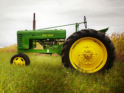 A green collector tractor parked in a field.