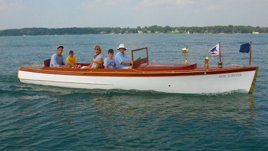 A family of five posing for a photograph on a white collector boat.