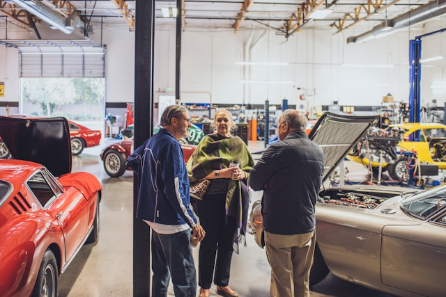 Car enthusiasts conversing in a garage