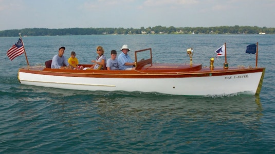 A family of five posing for a photograph on a white collector boat.