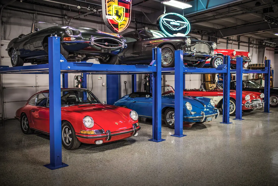 Seven collector cars parked on or below service lifts inside the Hagerty Learning Garage.