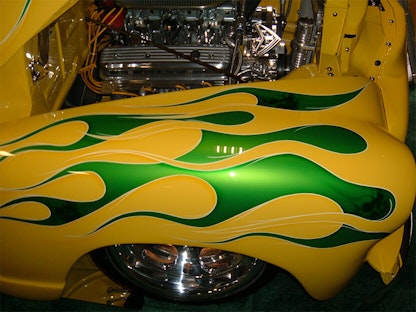 A close-up of a yellow collector vehicle with a green custom paint job.