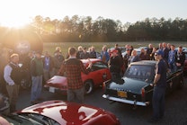 Group of people gathered around classic cars