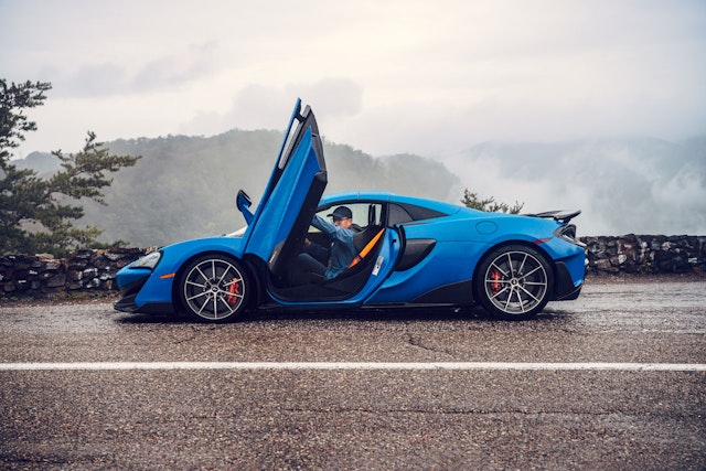 A blue McLaren parked with open doors