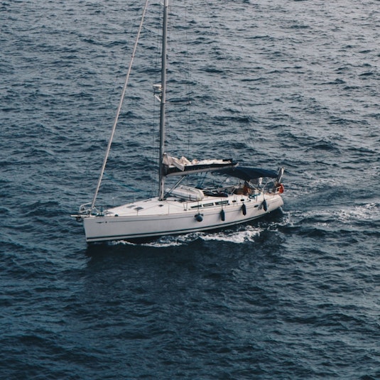 A white yacht floats on dark blue water.