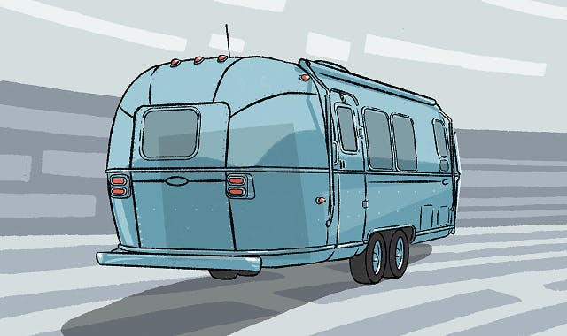 A baby blue Airstream Bambi style vintage camper trailer