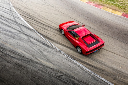 A bird's eye view of a red Ferrari on a race track