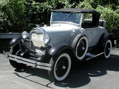 A replica of a 1980 Shay Model A, with trees in the background.