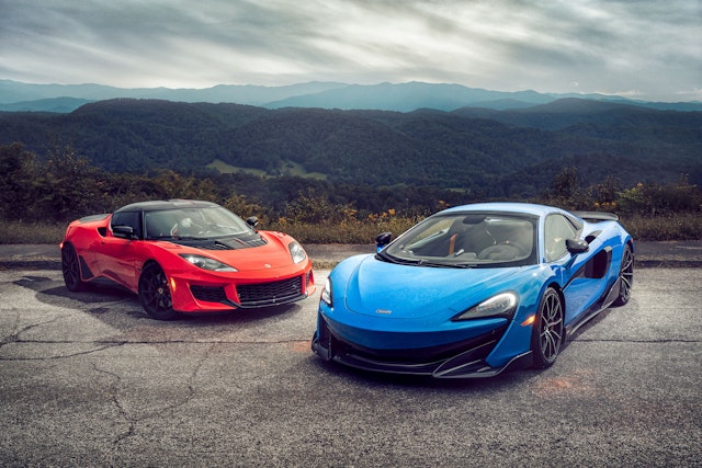A red Lotus and a Blue McLaren parked on a hill